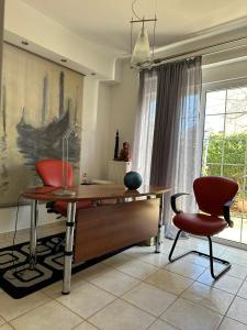 a desk and chairs in a room with a window at Villa Ariadni in Patra