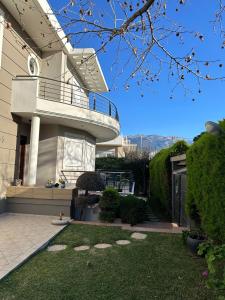 a house with a balcony and a yard at Villa Ariadni in Patra