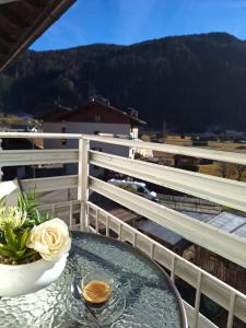 a glass table with a bowl of flowers on a balcony at Centro Mezzano Romantica, affitto camere in Mezzano