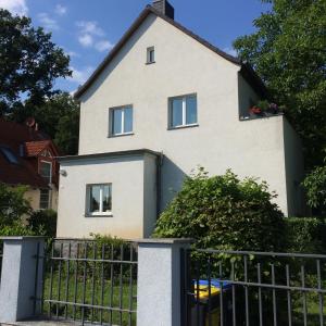 une maison avec une clôture devant elle dans l'établissement Freiraum Loft, à Markkleeberg