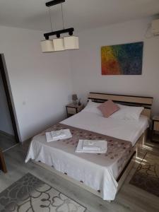 ein Schlafzimmer mit einem Bett mit zwei Geschirr drauf in der Unterkunft Vila Aliss in Mamaia Nord – Năvodari