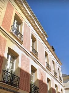 a red brick building with windows and balconies at Le 16 - Versailles Château in Versailles