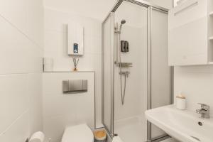 a bathroom with a shower and a toilet and a sink at FREE LIVING - City Design Apartments, Zentrum, Outlet, Balkon, Küche in Wolfsburg +80 photos