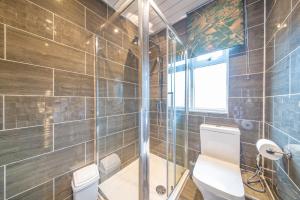 a bathroom with a toilet and a glass shower at *RA75L* For your most relaxed & Cosy stay + Free Parking + Free Fast WiFi * in Hunslet