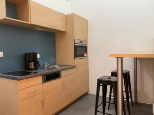 a kitchen with wooden cabinets and a sink and a counter at Fabella Flats Forchheim in Forchheim