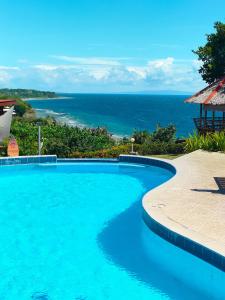 a swimming pool with a view of the ocean at Grandview Cottages Resort in Siaton