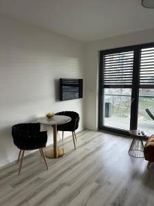 uma sala de estar com mesa e cadeiras em Ein Park Apartment with free parking em Bratislava