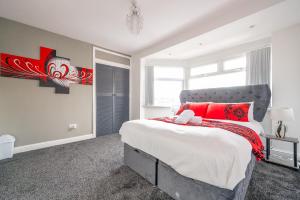 a bedroom with a large bed with red pillows at *RA75L* For your most relaxed & Cosy stay + Free Parking + Free Fast WiFi * in Hunslet