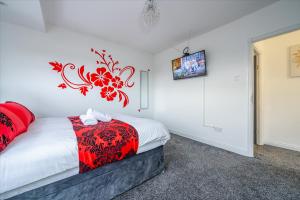 a bedroom with a bed with a red comforter at *RA75L* For your most relaxed & Cosy stay + Free Parking + Free Fast WiFi * in Hunslet