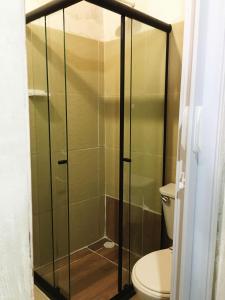 La salle de bains est pourvue d'une douche en verre et de toilettes. dans l'établissement Hostel Itaparica, à Itaparica Town