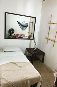 a bedroom with two beds and a mirror on the wall at Hostel Itaparica in Itaparica Town