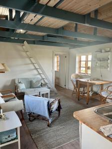 een woonkamer met een trap en een tafel bij Mormors Gårdhus ved stranden in Rude