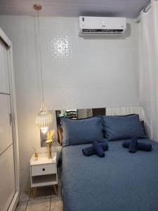 a bedroom with a blue bed with blue pillows at Casa Completa Prox Centro de Pipa in Pipa