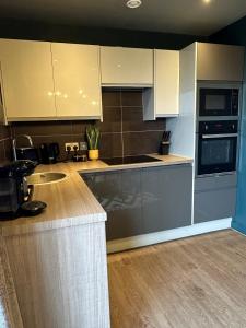 Una cocina con gabinetes blancos y encimera. en EPIC Apartments Tunnage Square, en Liverpool 13 fotos más
