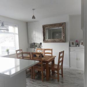 a dining room with a table and chairs and a mirror at Havendene in Haworth