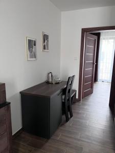 a room with a desk with two chairs and a door at Apartmány Siesta in Poľný Kesov