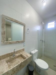 a bathroom with a sink and a toilet and a mirror at Hospedaria Valdice Damasceno Centro Histórico in Piranhas