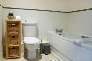 a bathroom with a toilet and a bath tub at Cosy 2-Bedroom Flat in Warrington in Warrington