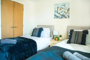 a bedroom with two beds with blue and white at Cosy 2-Bedroom Flat in Warrington in Warrington