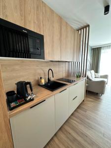 a kitchen with a sink and a microwave at Apartamenty Belona in Stegna