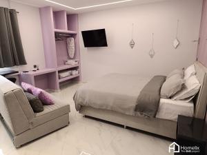 1 dormitorio con 1 cama, 1 silla y TV en Modern studio in the city center en Chalkida