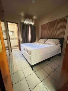 a bedroom with a large bed with a wooden headboard at 3 Quartos da UFU in Uberlândia