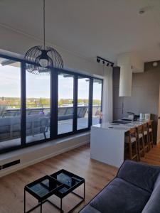a kitchen and a living room with a large window at Artisa Riia Str 20a Luxury Penthouse Apartment in Tartu