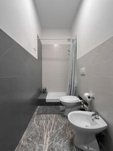 bagno bianco con servizi igienici e lavandino di Pascià Rooms a Roma