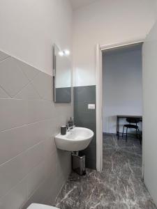 bagno bianco con lavandino e specchio di Pascià Rooms a Roma