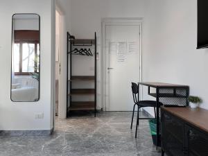 Zimmer mit einem Tisch, einem Spiegel und einer Tür in der Unterkunft Pascià Rooms in Rom
