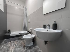 bagno bianco con lavandino e servizi igienici di Pascià Rooms a Roma
