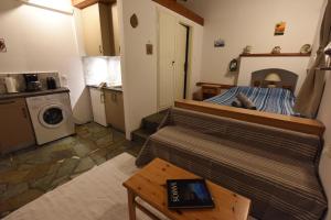 a small living room with a bed and a table at The Kalivi in Samos