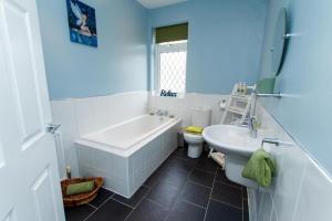 a bathroom with a tub and a sink and a toilet at Peak Period Property in Chesterfield