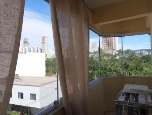 a balcony with a view of a city skyline at Linda Cobertura duplex compartilhada a duas quadras do mar in Itapema
