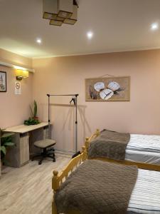 a bedroom with two beds and a desk and a desk at Green Lake Park Apartments in Vecsés