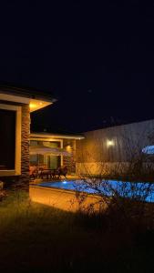 une maison avec une terrasse et une piscine la nuit dans l'établissement Villa Viyana Duo, à Fethiye