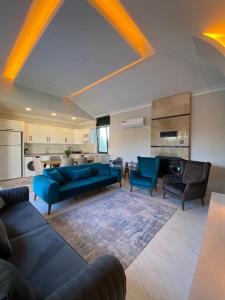 een grote woonkamer met blauwe banken en stoelen bij Villa Viyana Duo in Fethiye