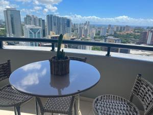 een tafel en stoelen op een balkon met een cactus bij Flat Boulevard Side 2104 Altissimo Padrão com Lazer in Salvador