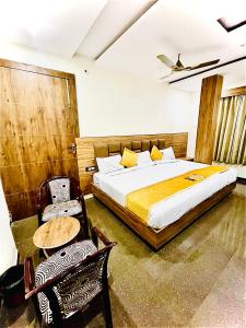 a bedroom with a bed and a table and chairs at Hotel Lime Tree by Madhav in Mathura