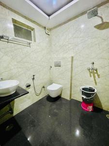 a bathroom with a toilet and a sink in it at Hotel Lime Tree by Madhav in Mathura