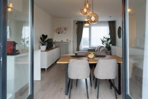 a kitchen and living room with a wooden table and chairs at Heights of Kortrijk in Kortrijk