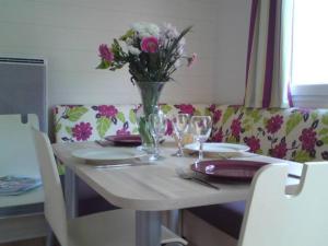 una mesa con un jarrón de flores encima en Camping Las Asperas*** en Palau-de-Cerdagne
