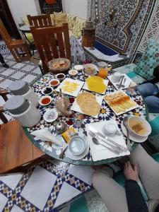 a table with food on it with people sitting around it at Riad Fes Colors & Spa in Fès