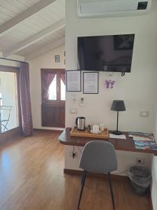 Habitación con escritorio, silla y TV. en Al San Michele, en Stresa