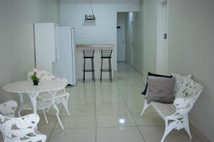 a dining room with a table and chairs and a white table and chairs at Hospedaria Valdice Damasceno Centro Histórico in Piranhas