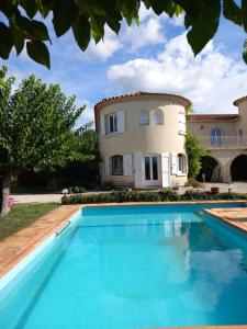 Villa con piscina frente a una casa en le relais fleuri en Alès