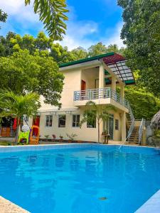 a house with a swimming pool in front of it at Coco Cavana Resort in Batangas City