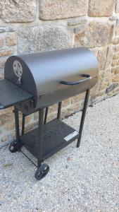 a grill sitting in front of a brick wall at Gîte d'Anne et Ulysse in Sept-Frères