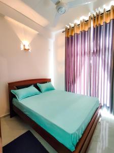 a bedroom with a large bed with a window at Shan Stay in Moratuwa