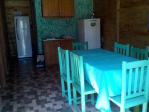 tavolo blu e sedie in cucina con frigorifero di CABAÑA DOÑA ANGELA 
